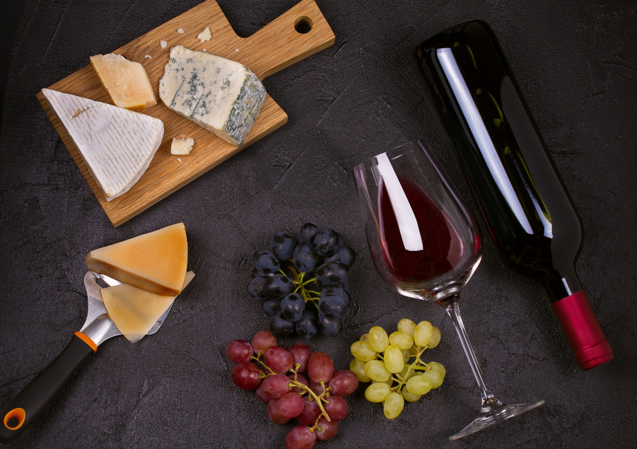 Red and white wine with cheese plate. Wine glasses with cheese, grapes ...